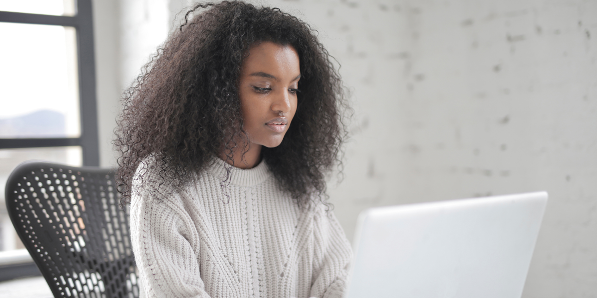 A person sitting at their desk typing on a laptop.