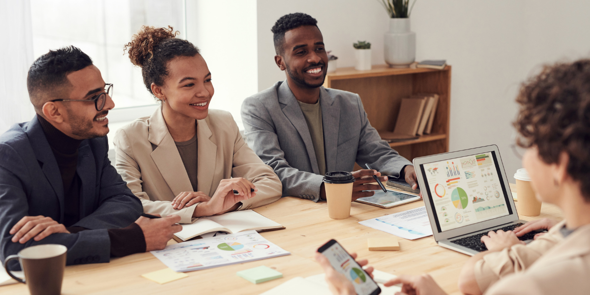 A group of people sitting at a boardroom table conversing.