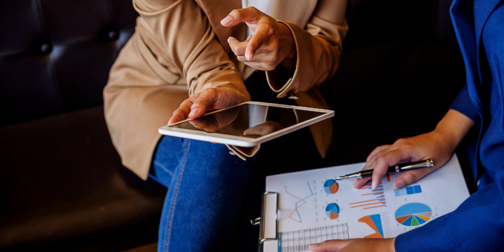 Two people are sat side-by-side and are reviewing financial statements.
