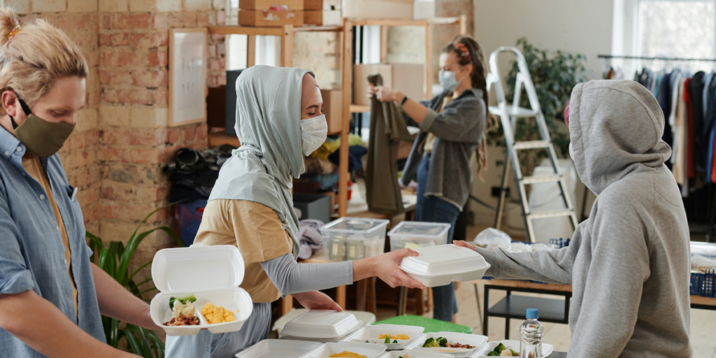 Volunteers wearing medical-grade masks are volunteering at a food bank.