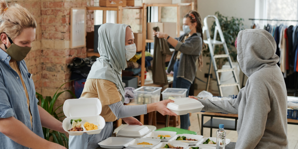 Volunteers wearing medical-grade masks are volunteering at a food bank.