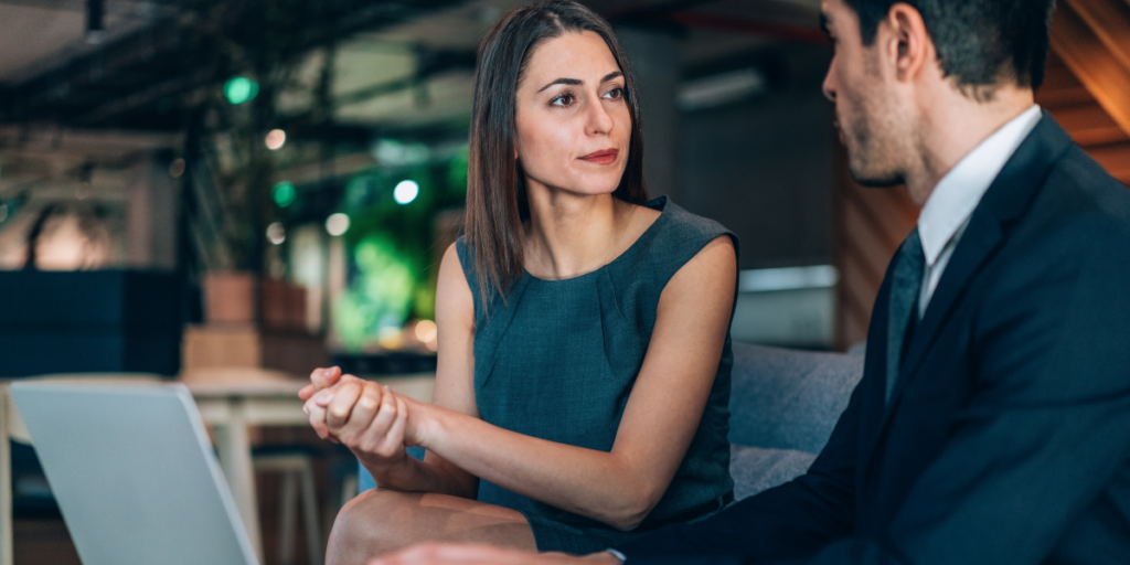 Two people sitting side-by-side conversing.