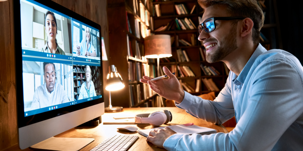 A man is sitting at a desk participating in a virtual meeting.