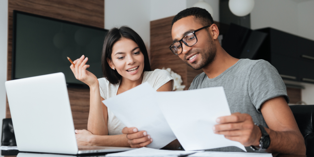 Two individuals sat side-by-side reviewing paperwork.