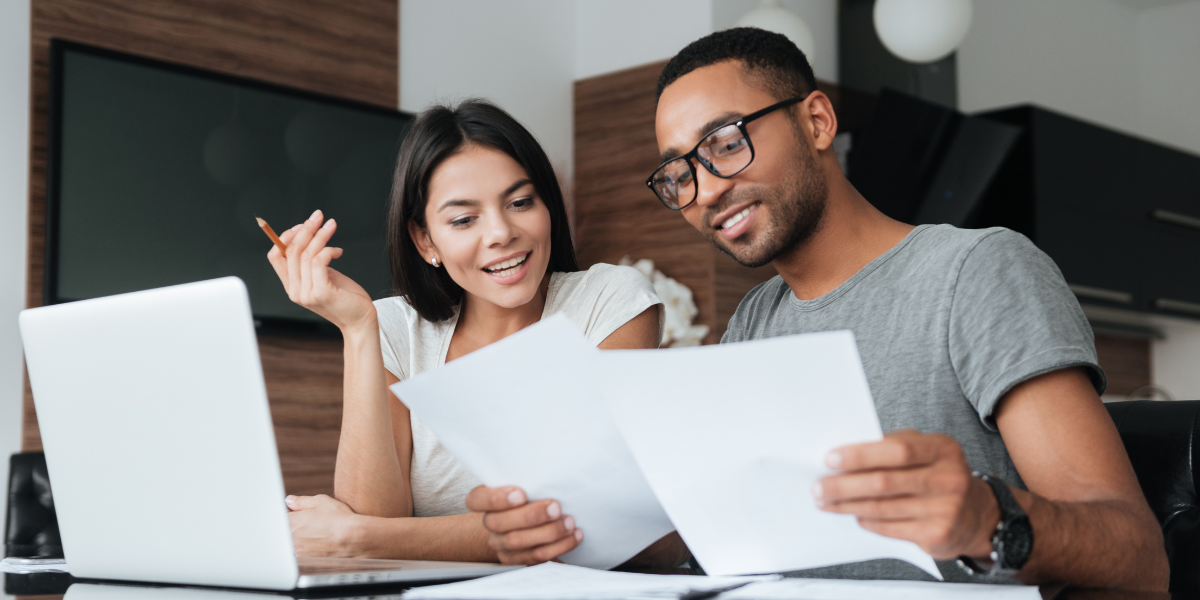Two individuals sat side-by-side reviewing paperwork.