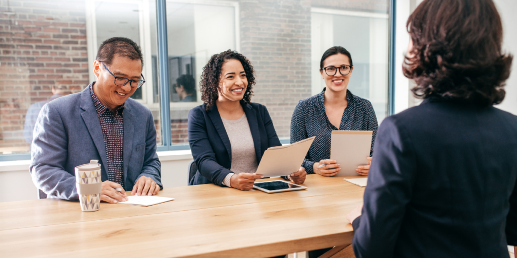 A panel of three people are interviewing a candidate.