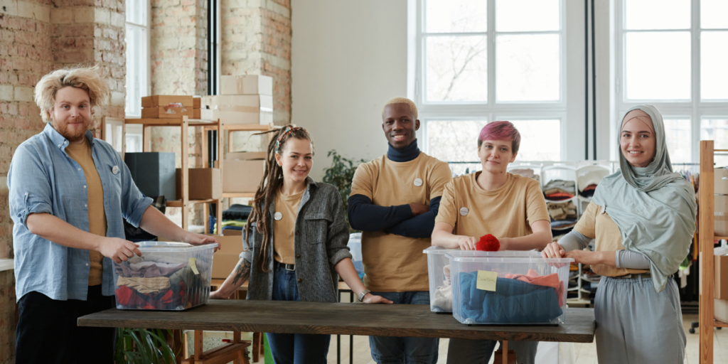 A group of volunteers in matching yellow shirts volunteering at a clothing driving.