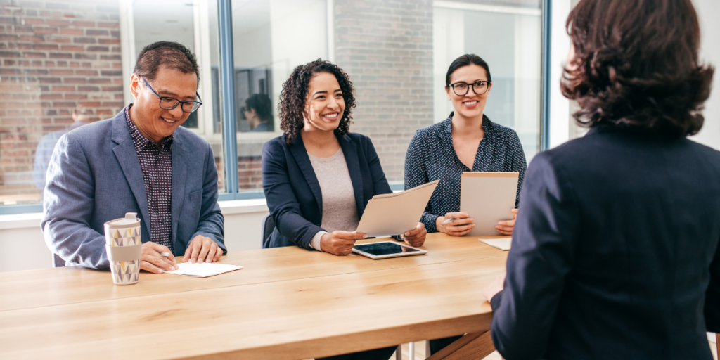 A panel of three people are interviewing a candidate.