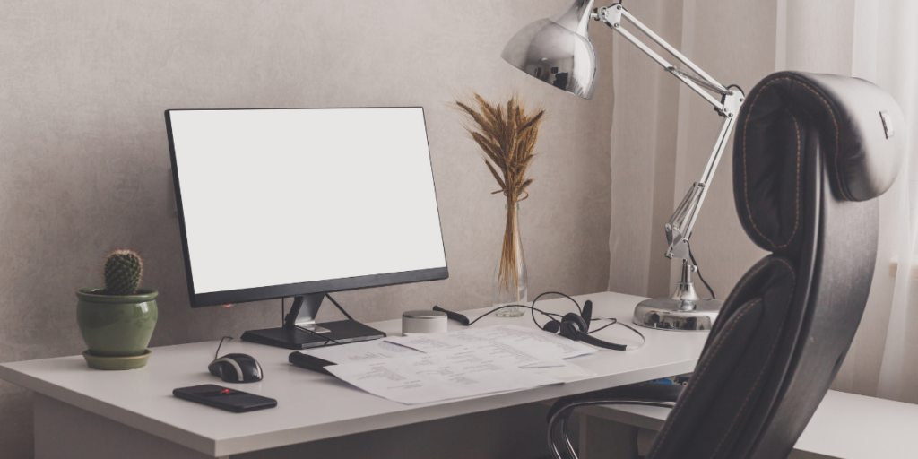 An office set up with a computer desktop and a chair.