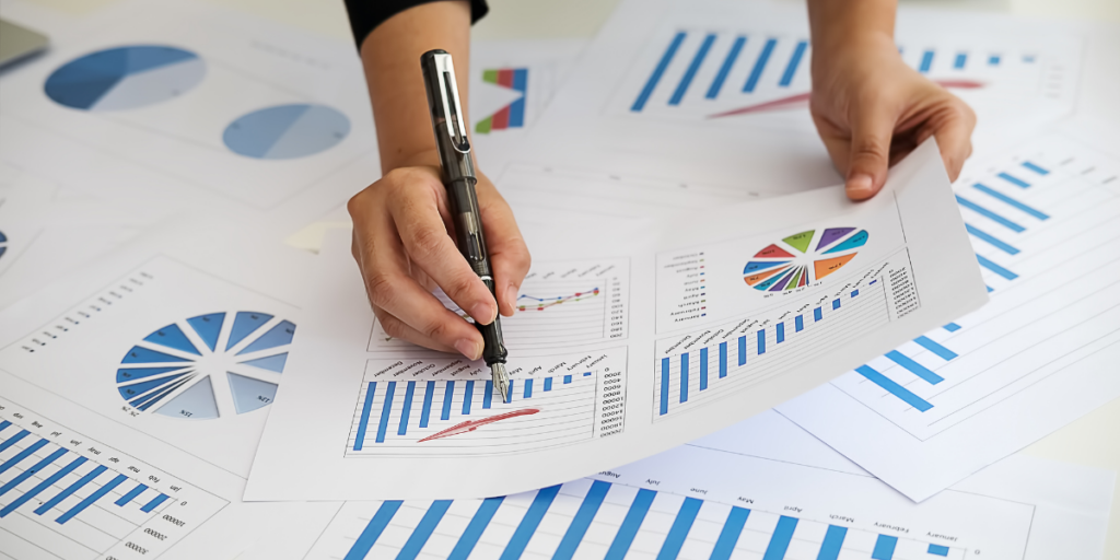 A person sitting at a desk reviewing financial documents and taking notes.