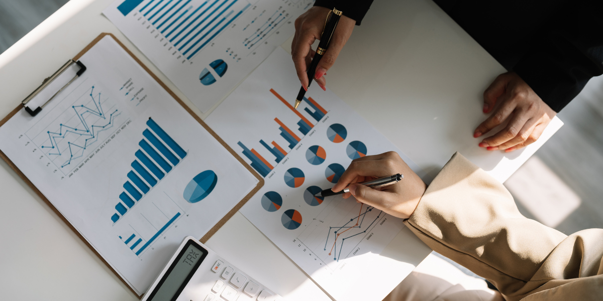 Two people sitting at a desk reviewing financial documents and taking notes.