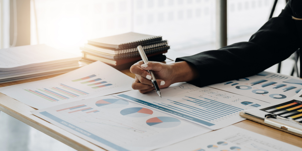 A person sitting at a desk taking notes on charts.