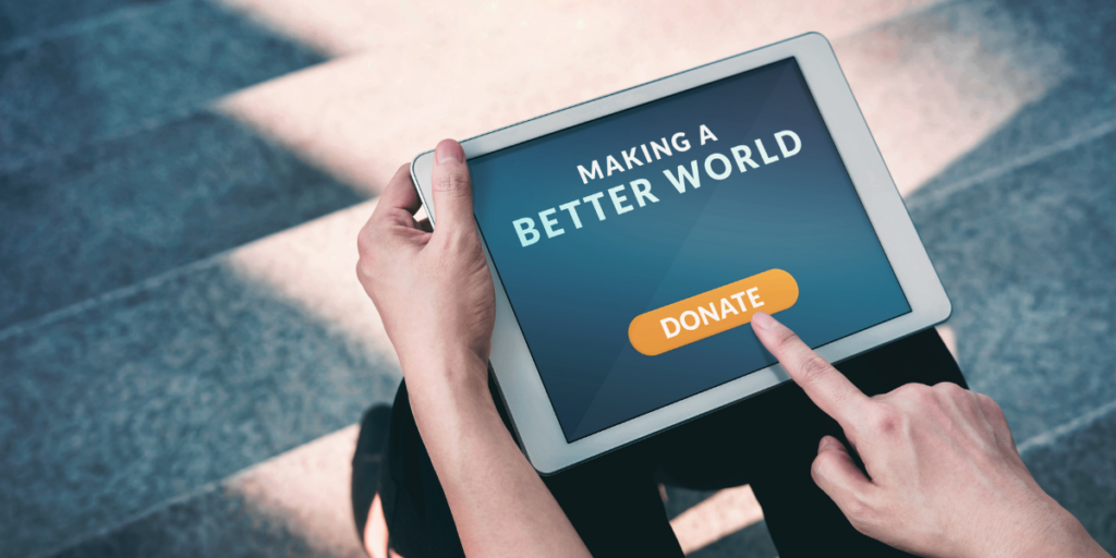 A person sitting on concrete steps holding a tablet with the text: "Making a better world - donate!".