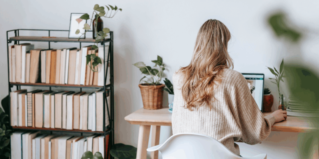 A woman is sat at her desk working on her computer.