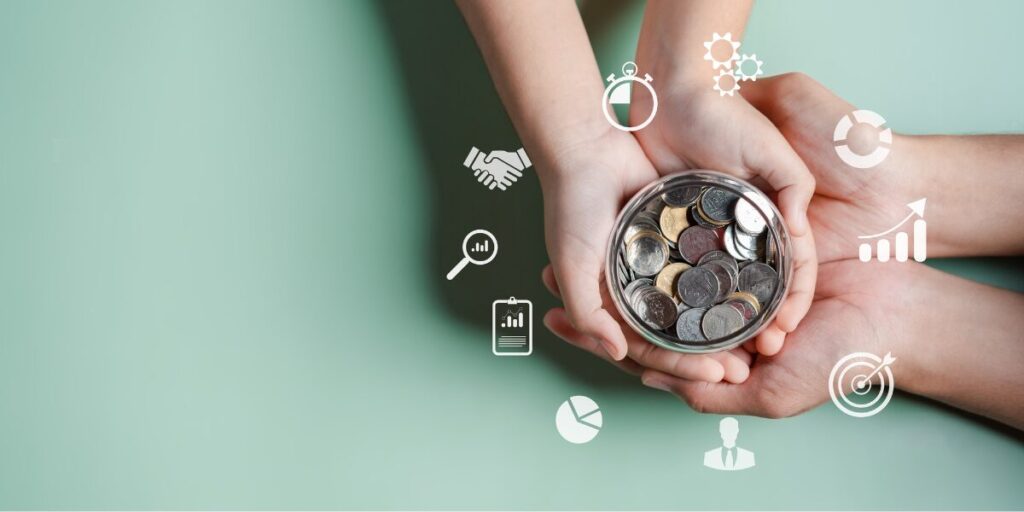 Two pairs of hands are cradling a jar of coins representing fundraising and donations.