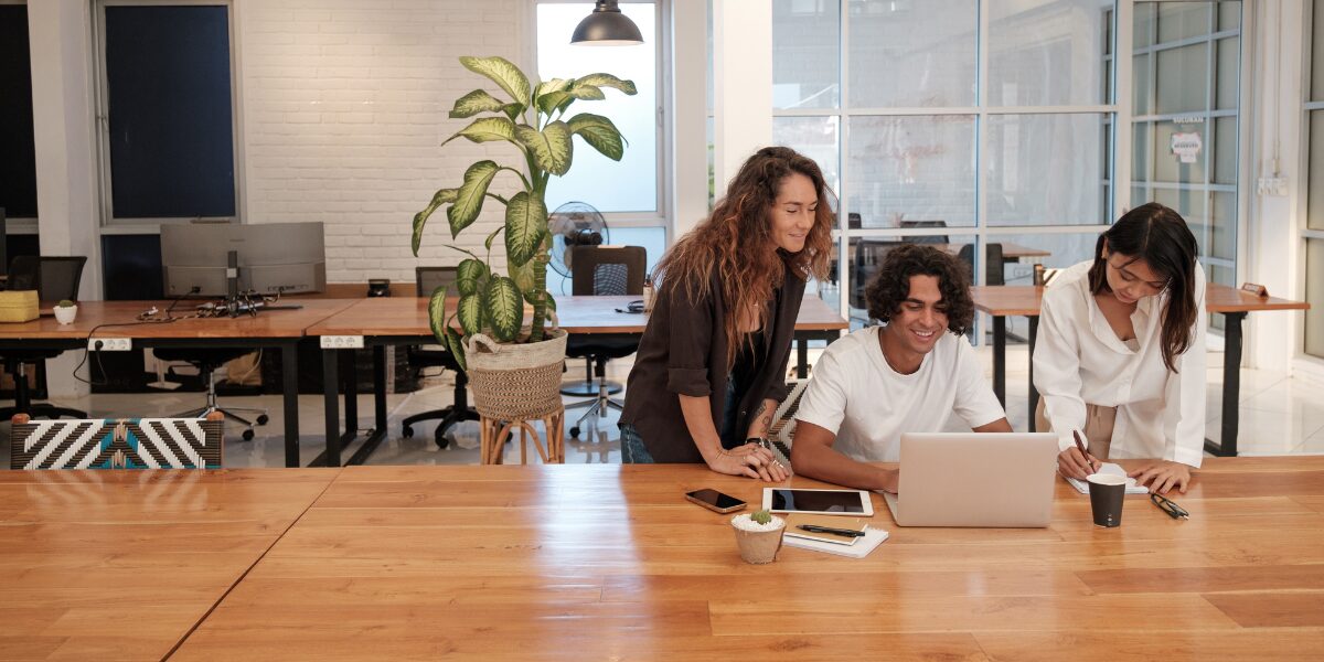 Three people working in a well-lit boardroom.